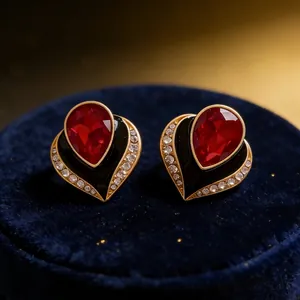 Makrodetail von Vintage-Herzohrringen mit roten Edelsteinen und schwarzer Emaille-Einlage
