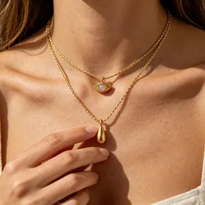 Macro view of French vintage gold double-layer necklace with evil eye and teardrop pendants.