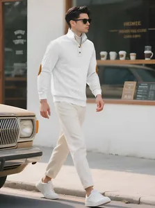 Detailed side view of white jacquard knit sweater with elbow patches on a male model.