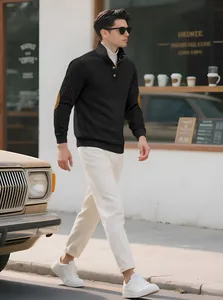 Detail view of men's black jacquard knit sweater with stand collar and elbow patches