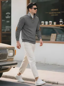 Casual outdoor shot of male model wearing a grey textured knit sweater with stand collar