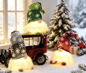 Three lighted Christmas gnomes with glowing beards and snowflake knit hats in a snow scene