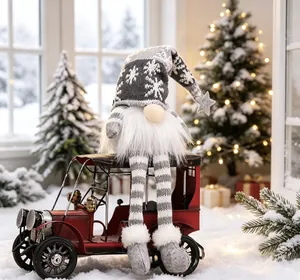 Detail showing a gray Christmas gnome sitting on a red vintage car in a snowy scene