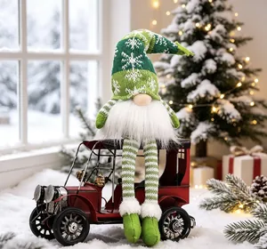 Festive glowing Christmas gnome sitting on a vintage red car in snow