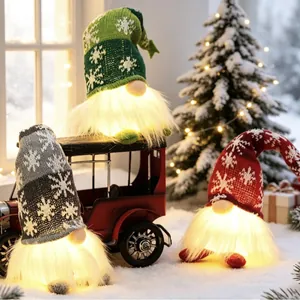 Three lighted Christmas gnomes with snowflake knitted hats in a festive winter scene