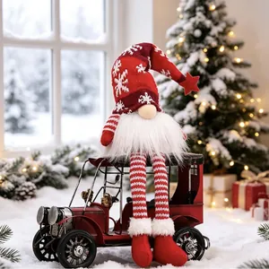 Festive Christmas gnome faceless doll sitting on a red vintage toy car in snowy scene