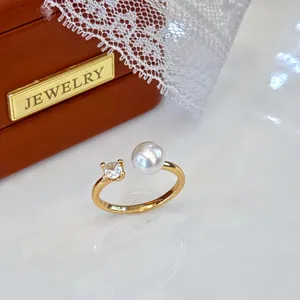 Detailed close-up of adjustable gold ring with freshwater pearl and sparkling stone