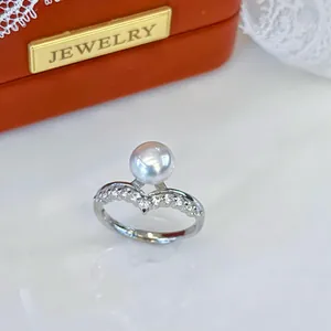 Close-up of elegant adjustable silver ring with natural freshwater pearl and zircons