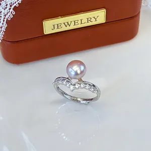 Detailed view of an adjustable silver ring with a pink freshwater pearl and zircon