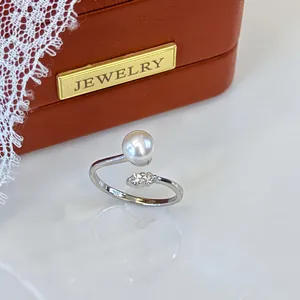 Close-up view of an elegant adjustable silver ring with a white pearl and sparkling crystals