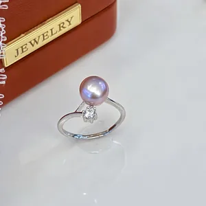 Close-up of a silver adjustable ring featuring a pink freshwater pearl and zircon