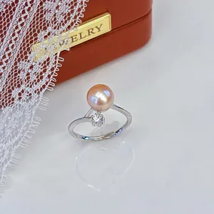 Macro view of a shimmering pink freshwater pearl ring with a dainty crystal accent.