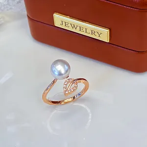 Detailed view of freshwater pearl ring with rose gold leaf pattern and pave stones