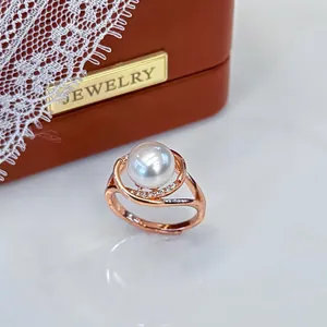 Detailed view of an elegant rose gold adjustable ring with a large white pearl and crystals.
