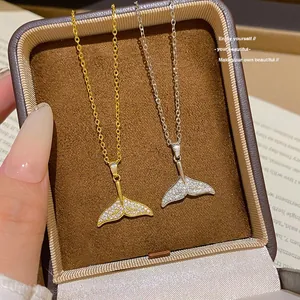 Primo piano di collane con coda di sirena in oro e argento con zirconi luccicanti