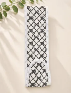 Close-up view of plush magic tape headband with black bow pattern for face washing