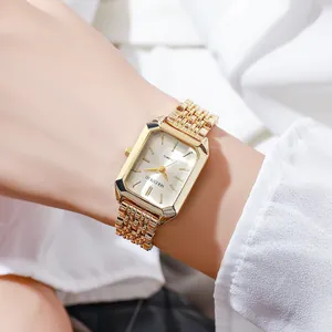 Close-up of gold rectangular women's watch with elegant steel band link.