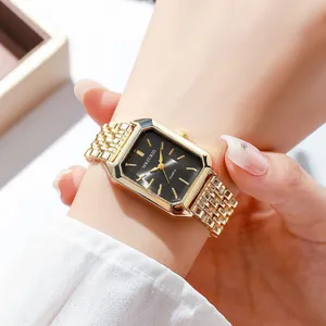 Close-up of elegant square gold women's watch with black dial and golden steel band