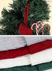 Close-up of cable knit textures on red, white, and green Christmas stockings.