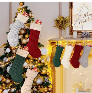 Cozy multi-colored cable knit Christmas stockings hanging by the fireplace and tree