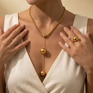 Detailed close-up showing a gold-plated titanium steel necklace and ring set on an Asian model