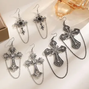Vista dettagliata di eleganti orecchini a croce gotici vintage con catene e strass