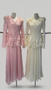 Detailed view of lace peplum tops and pleated maxi skirts in pink and cream colors.