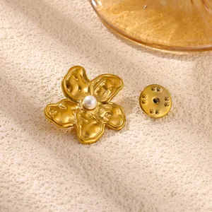 Detailansicht einer goldenen Vintage-Blumenbrosche mit strukturierter Oberfläche und Perle