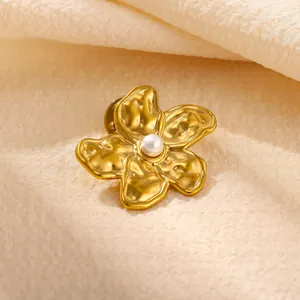 Detailansicht einer Vintage Goldblumenbrosche mit Hammerschlag-Textur und edler Perle.