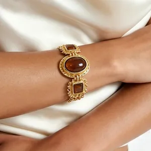 Nahaufnahme eines goldenen Vintage-Barockarmbands mit bernsteinfarbenen Harzsteinen.