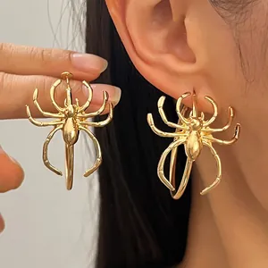 Detail shot of vintage gothic style gold spider pendant earrings on a female model