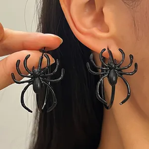 Macro detail shot of gothic black spider earrings worn and held by an Asian model