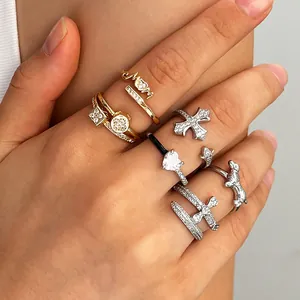 Close-up of stacked gold and silver open rings with cz heart and cross motifs
