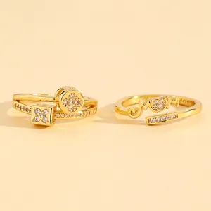Close-up of zircon-inlaid gold rings featuring geometric patterns and MOM script.