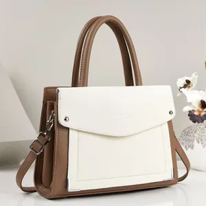 Close-up of a stylish brown and white textured PU leather handbag with top handle