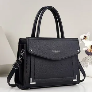 Close-up of a black square PU leather handbag with a textured finish and top handle.