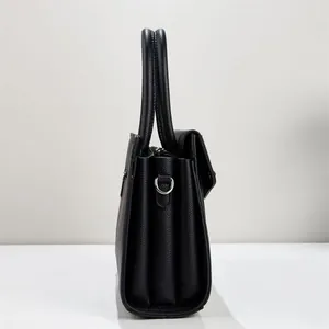 Side view detail of black lychee pattern PU leather handbag with accordion structure