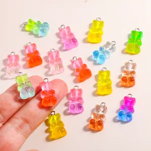 Detail view of colorful transparent gummy bear resin charms showing size scale in hand