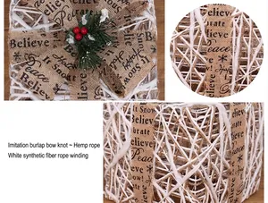 Detail of white woven Christmas gift box with burlap bow and red berries