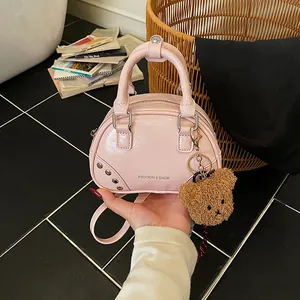 Mini pink patent leather bowling bag featuring a cute teddy bear keychain detail