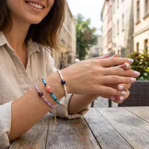 Set of three trendy beaded bracelets with macaron colored stones and gold chains.
