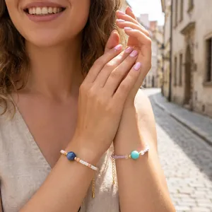 Close-up of macaron color beaded bracelets with square stones worn by a model