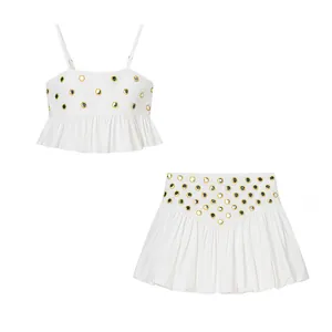 White two-piece cami set with gold metallic mirror embellishments and pleated hem