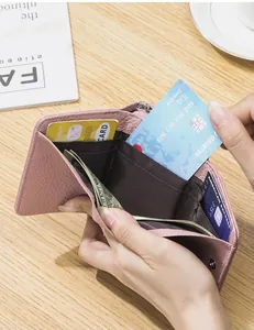 Innenansicht einer rosa Lederbrieftasche mit Fächern für Karten und Bargeld im Detail.