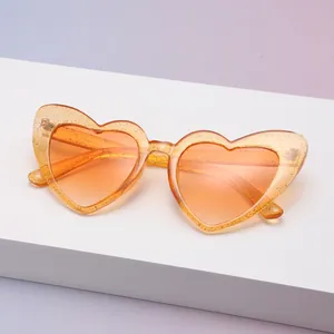 Detailansicht der orangefarbenen Herz-Sonnenbrille mit Glitzerfinish und UV400-Schutzgläsern
