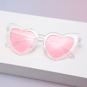 Detailansicht der pinkfarbenen Herz-Sonnenbrille mit Glitzerrahmen und UV400-Schutz.