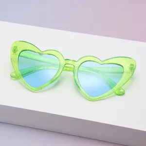 Nahaufnahme der stilvollen grünen Herzsonnenbrille mit Glitzer und Blauverlauf