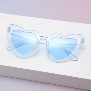 Detailansicht der herzförmigen Sonnenbrille mit hellblauem Glitzerrahmen und UV400-Schutzfolie