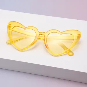 Detailaufnahme einer gelben herzförmigen Sonnenbrille mit glitzerndem Kristallgestell