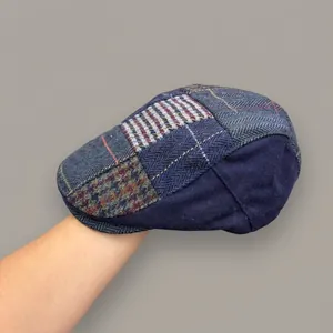 Nahaufnahme einer Vintage-Schiebermütze mit blauem Patchwork und Karomuster.